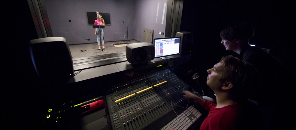 Student in a Foley stage and professor in a sound booth